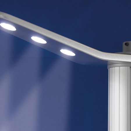 Eine moderne, metallische Lampe mit drei LED-Leuchten, montiert auf einem schlanken zylindrischen Sockel